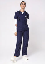 Front view of a model in the Knya Classic V-Neck Scrub Top and pants in navy blue